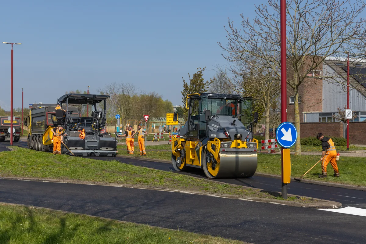Paving crew laying fresh asphalt