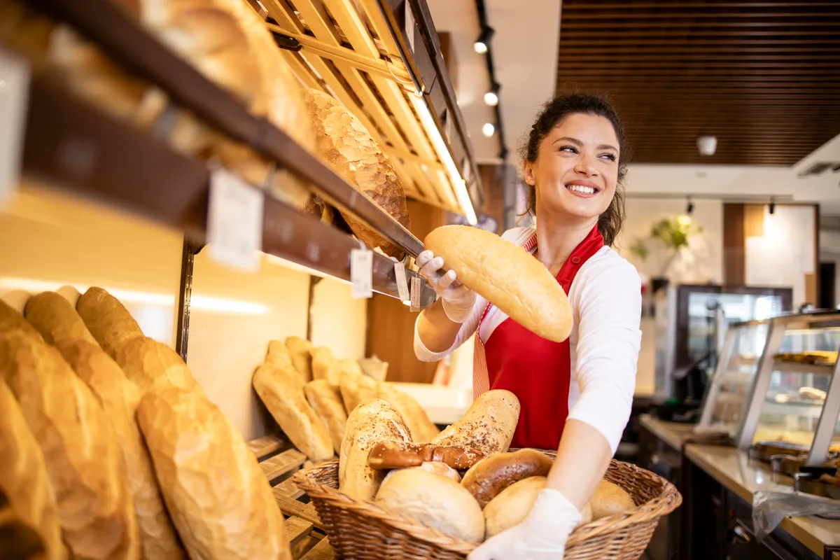 Bakery owner arranging fresh bread