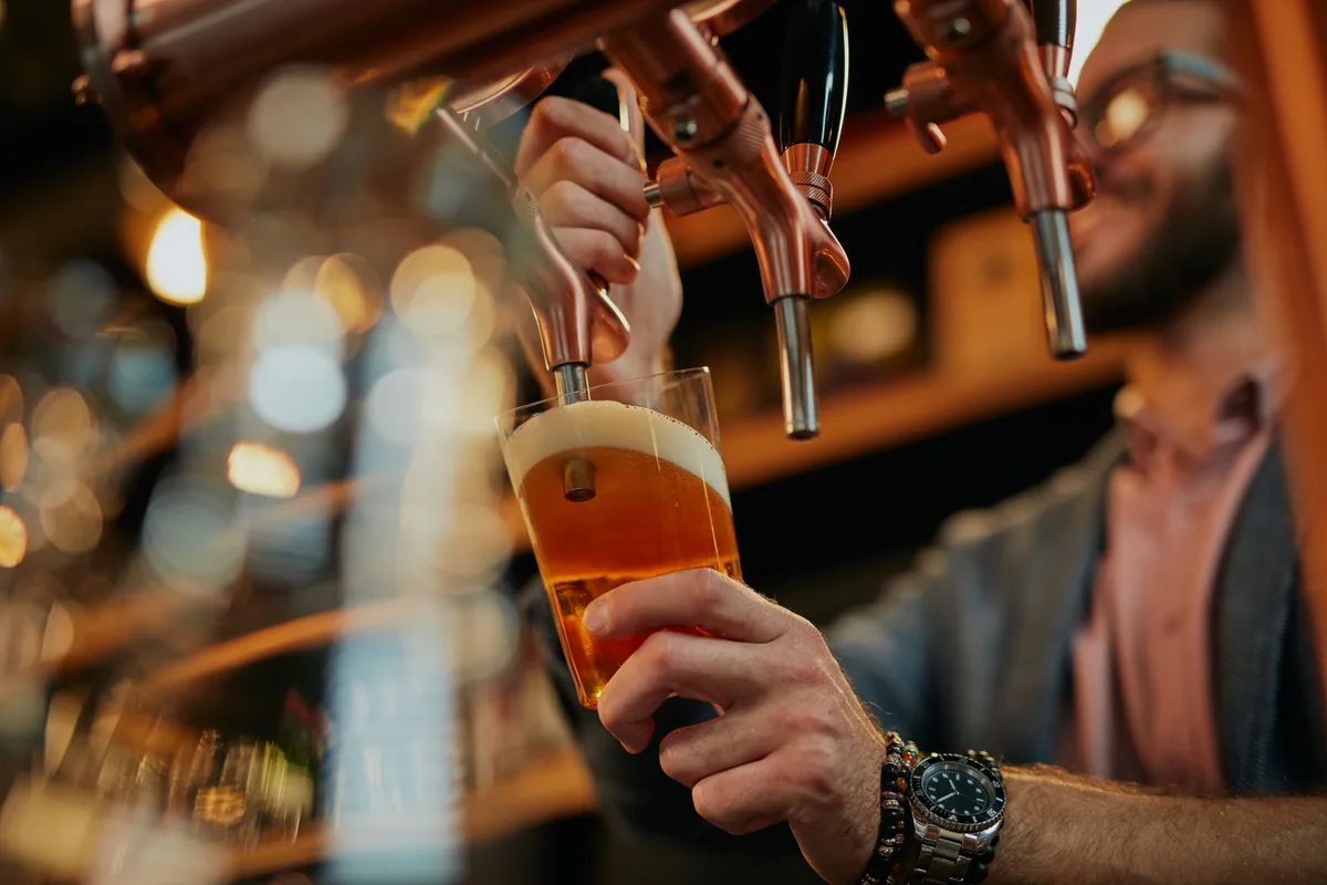 Bartender pouring a draught beer at the taps