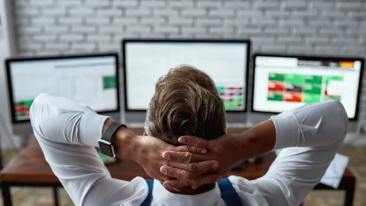 Trader at a multi-monitor desk
