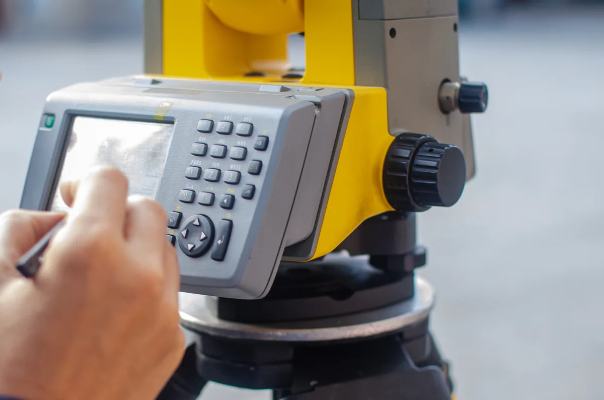 Land surveyor operating a total station on site