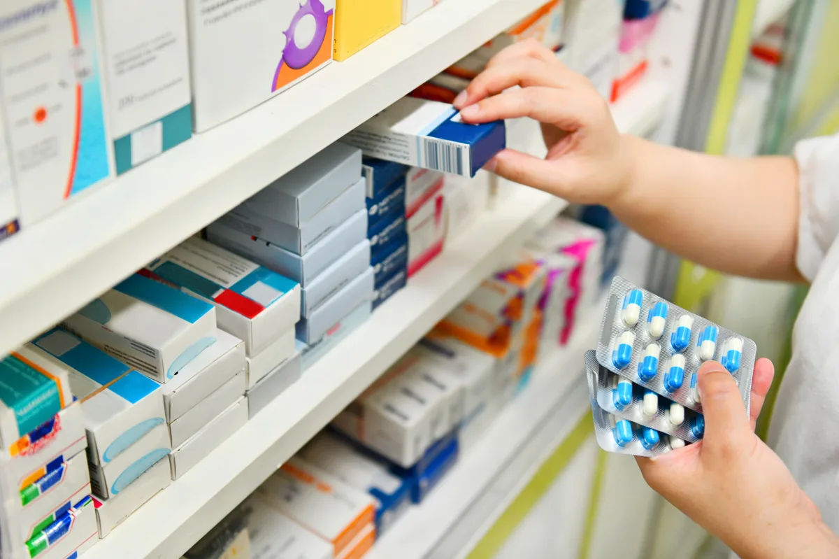 Pharmacist checking medication on a pharmacy shelf