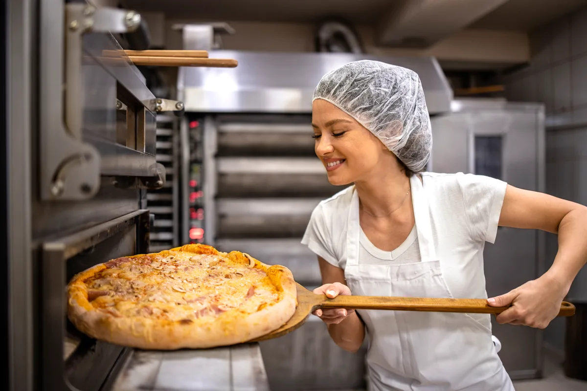 Pizza coming out of a shop oven