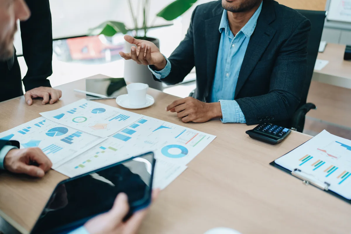 A CFO-level advisory meeting over printed reports and a tablet