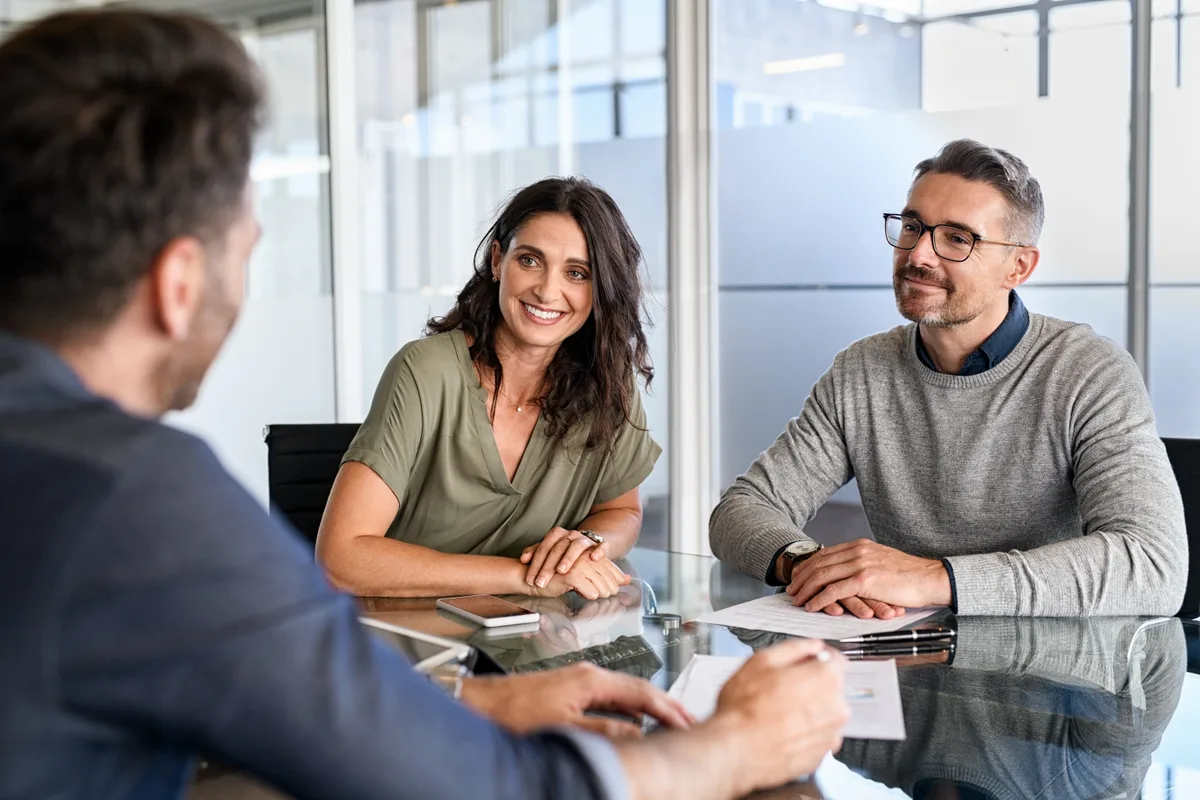 A couple meeting their financial advisor across a desk