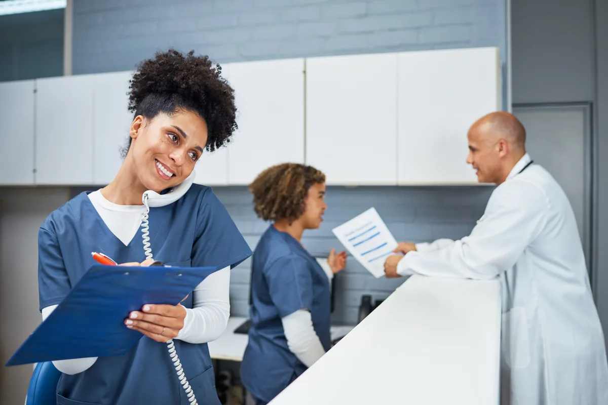 Clinic administrators and a physician at the front desk